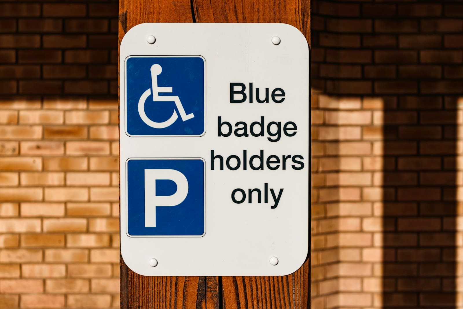 a blue and white sign that says blue badge holders only
